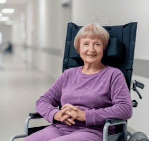 woman in wheelchair wearing purple lounge clothes in hospital hallway